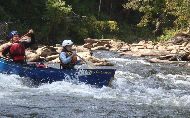 teens navigate whitewater on canoeing trip